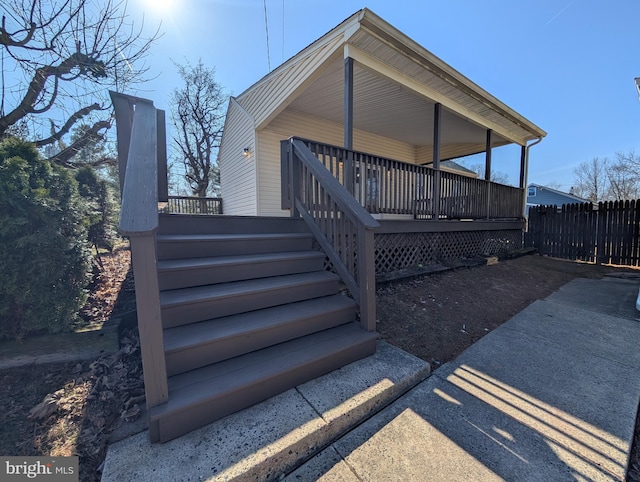 exterior space featuring stairway, fence, and a wooden deck