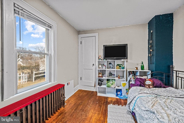 bedroom featuring wood finished floors and radiator heating unit