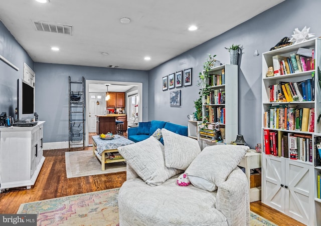 living room featuring dark wood finished floors, visible vents, recessed lighting, and baseboards