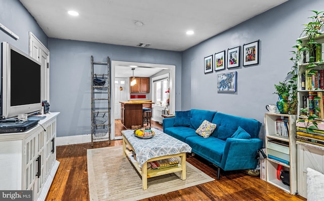 living room featuring recessed lighting, visible vents, dark wood-style flooring, and baseboards