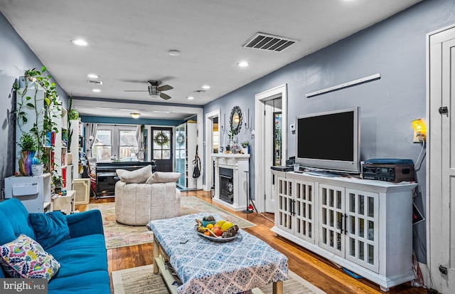 living area with recessed lighting, visible vents, wood finished floors, and a fireplace