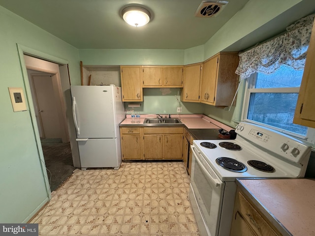 kitchen with white appliances, light floors, visible vents, and a sink