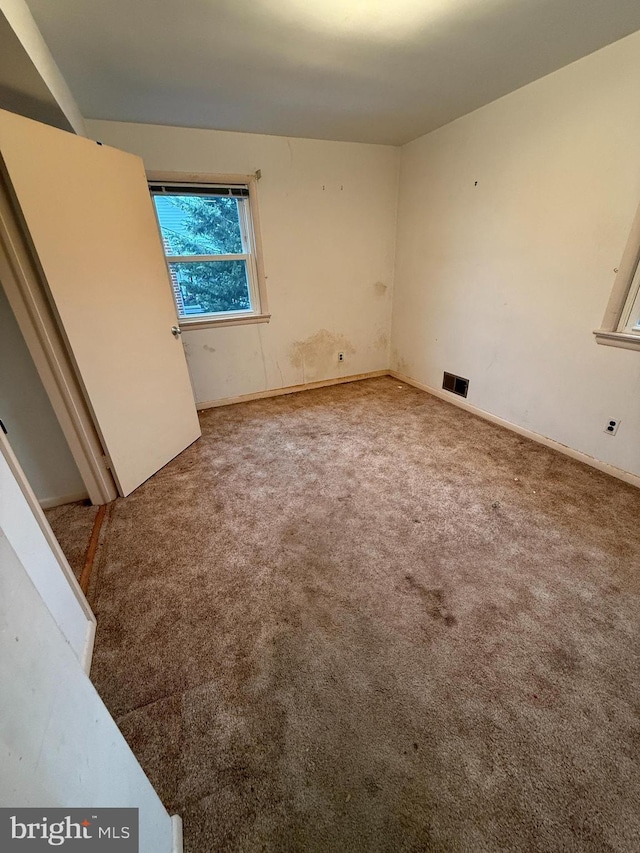 unfurnished bedroom featuring carpet flooring and visible vents