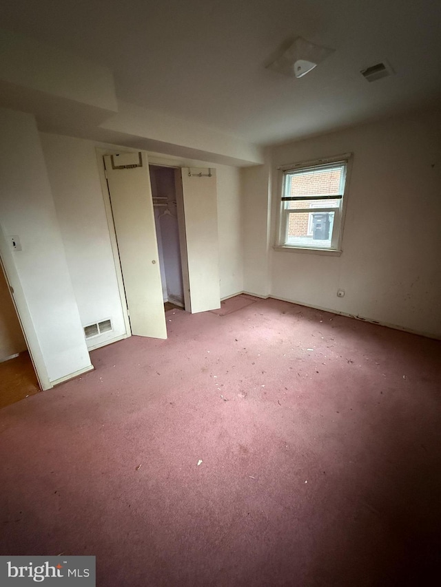 spare room featuring visible vents and light colored carpet