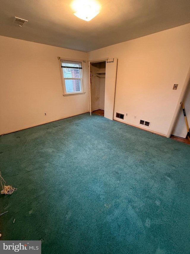 unfurnished bedroom with a closet, visible vents, and carpet floors