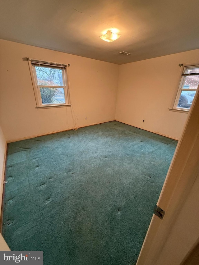 empty room featuring visible vents and carpet floors