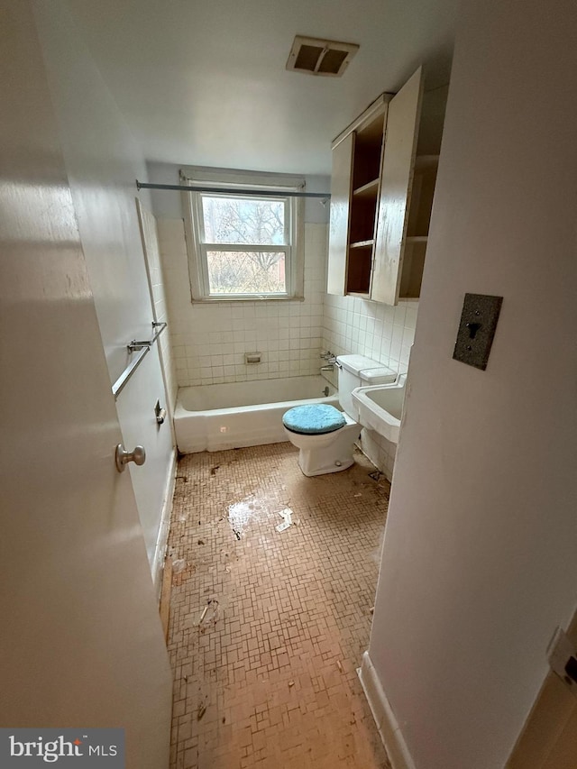 bathroom with visible vents, vanity, toilet, and washtub / shower combination