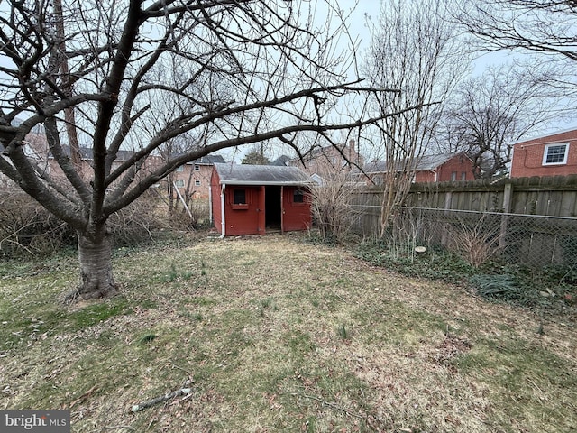 view of yard featuring an outbuilding, fence, and a shed