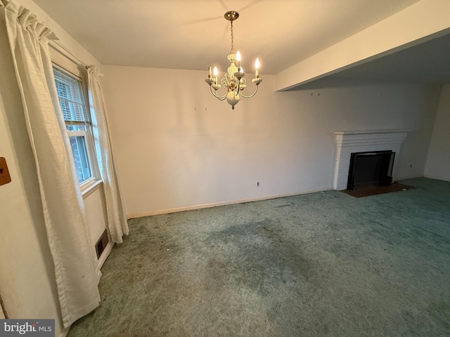 unfurnished living room with a fireplace with flush hearth, an inviting chandelier, visible vents, and carpet