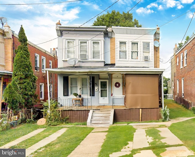 multi unit property with cooling unit, covered porch, and a front lawn