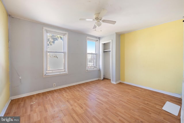 unfurnished bedroom featuring baseboards, light wood-type flooring, and a closet