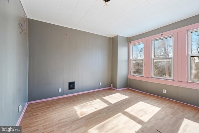 empty room with visible vents, baseboards, and wood finished floors