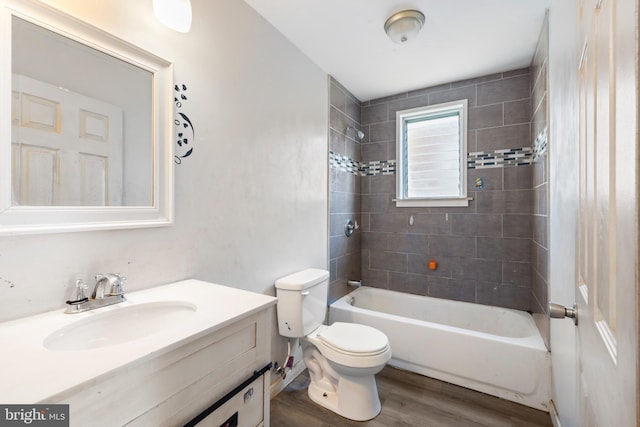 bathroom with vanity, toilet, wood finished floors, and tub / shower combination