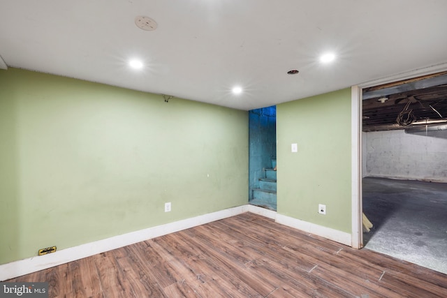 finished below grade area featuring recessed lighting, baseboards, and wood finished floors