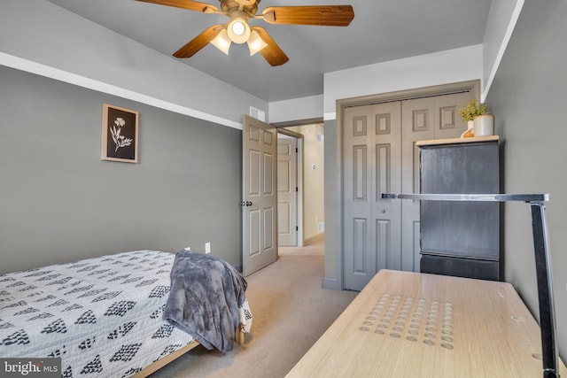 carpeted bedroom featuring a closet, baseboards, and a ceiling fan