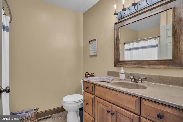 bathroom with vanity, baseboards, visible vents, tile patterned floors, and toilet