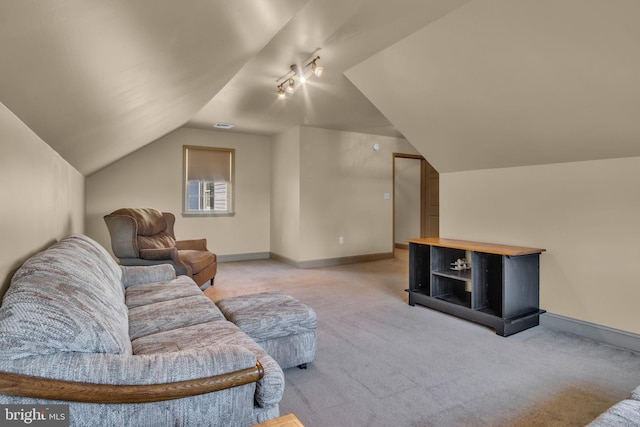 living room featuring vaulted ceiling, rail lighting, baseboards, and carpet floors