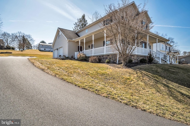 view of side of home with a porch and a lawn