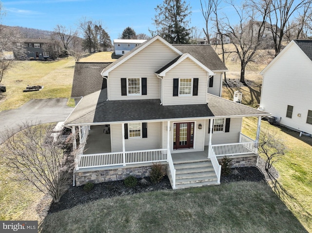 view of front of property featuring a front lawn, covered porch, and a shingled roof