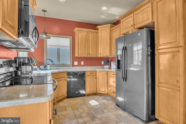 kitchen with light brown cabinetry, black appliances, light countertops, stone finish flooring, and pendant lighting