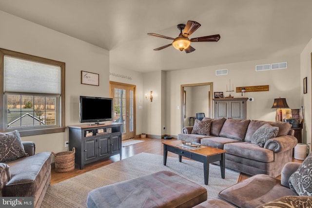 living area featuring visible vents, light wood-style floors, and ceiling fan