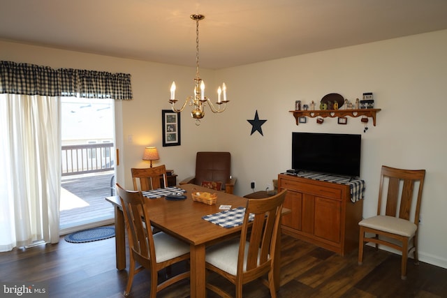 dining area featuring dark wood-type flooring and a notable chandelier