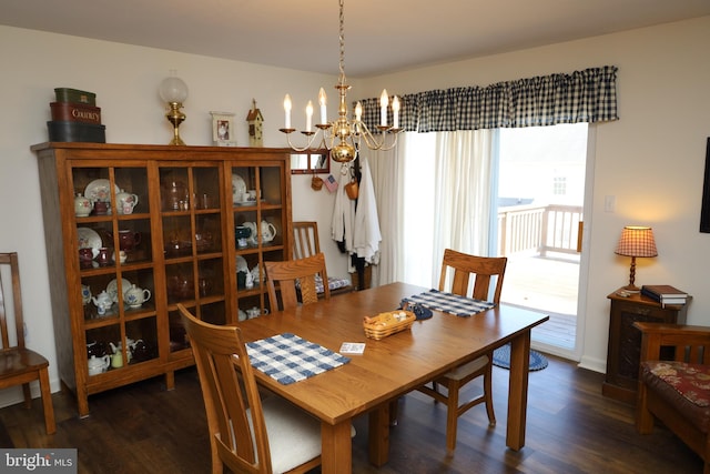 dining room with an inviting chandelier, dark wood-type flooring, and baseboards