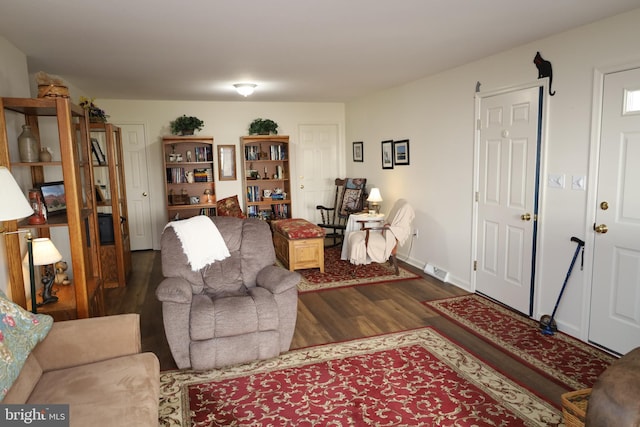 living room with visible vents, baseboards, and dark wood-type flooring