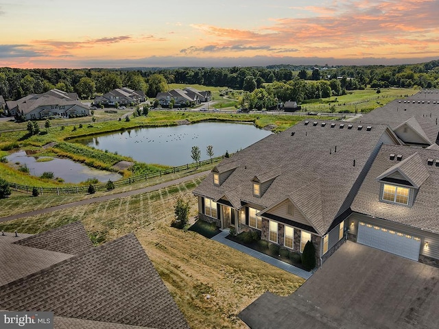 aerial view at dusk featuring a water view