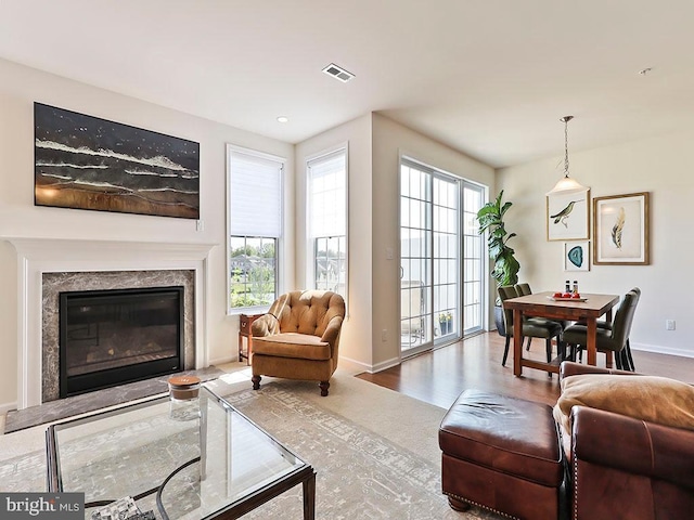 living room featuring visible vents, baseboards, and a fireplace