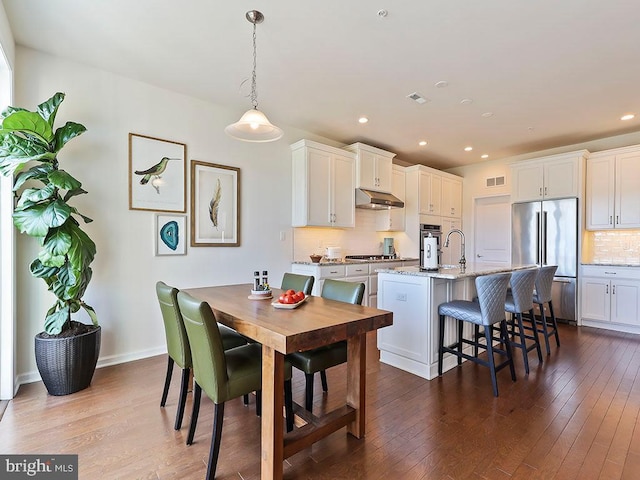 dining room featuring dark wood finished floors, visible vents, and recessed lighting