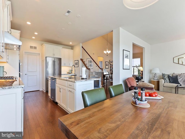 dining area featuring dark wood-style floors, visible vents, recessed lighting, and an inviting chandelier