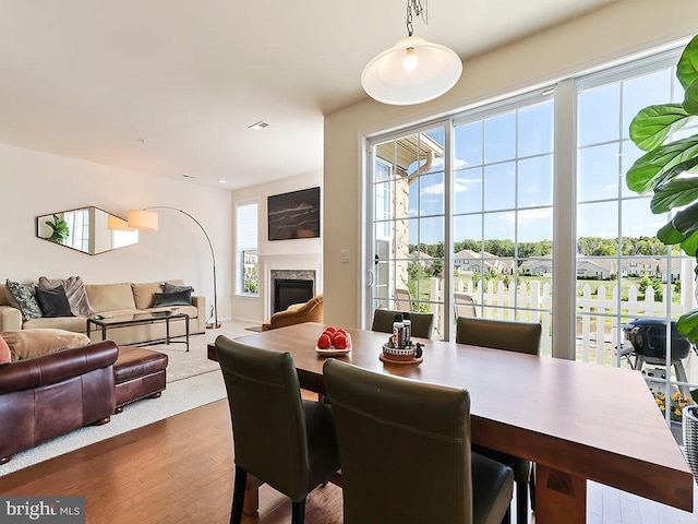 dining area featuring a premium fireplace and wood finished floors