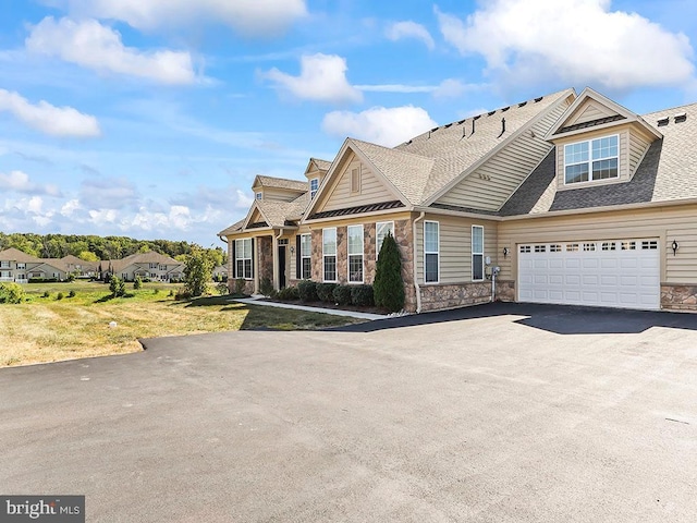 view of front of house with a garage, stone siding, driveway, and a shingled roof