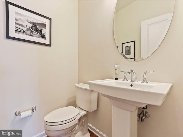 bathroom with toilet and baseboards