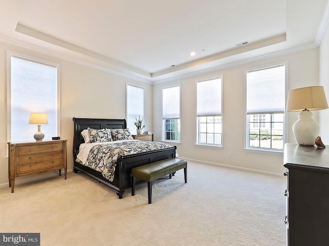 bedroom featuring a tray ceiling, ornamental molding, baseboards, and light carpet