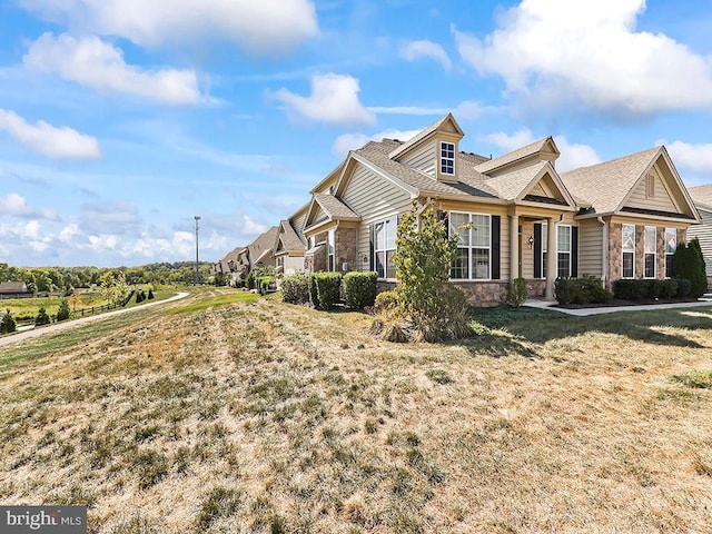 view of home's exterior featuring stone siding and a yard