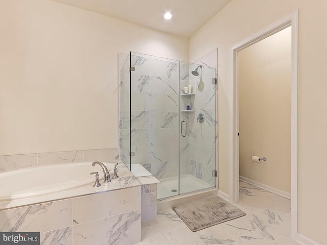 bathroom featuring a garden tub, baseboards, marble finish floor, and a shower stall