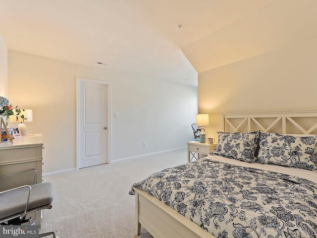 carpeted bedroom with lofted ceiling and baseboards