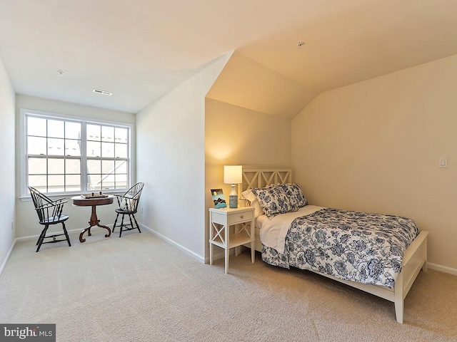 carpeted bedroom featuring visible vents, baseboards, and vaulted ceiling