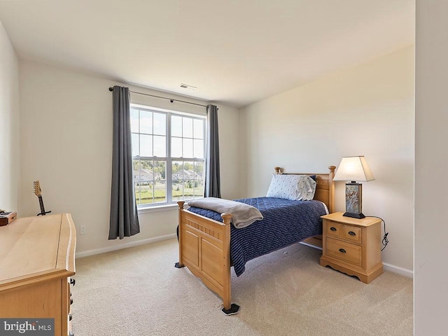 bedroom with baseboards, light carpet, and visible vents