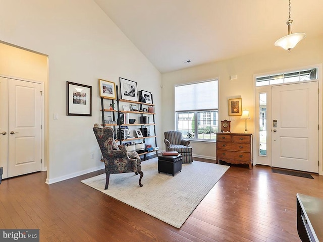 interior space with high vaulted ceiling, baseboards, and wood-type flooring