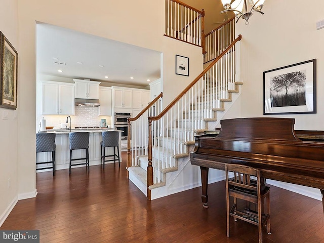 staircase with visible vents, baseboards, recessed lighting, hardwood / wood-style flooring, and a chandelier