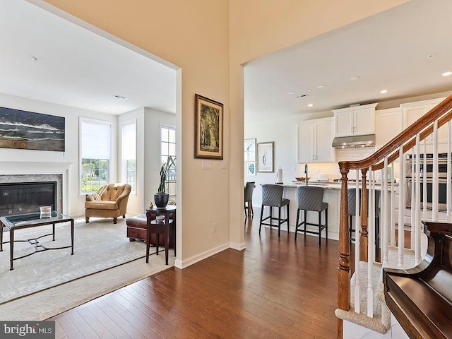 interior space with baseboards, stairway, a premium fireplace, recessed lighting, and dark wood-style flooring