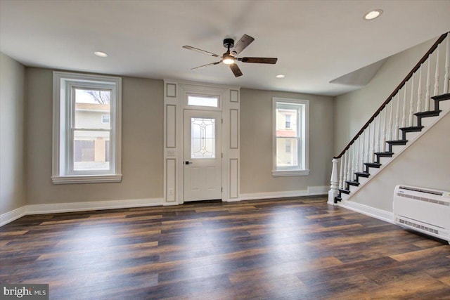 foyer with stairs, heating unit, and dark wood finished floors