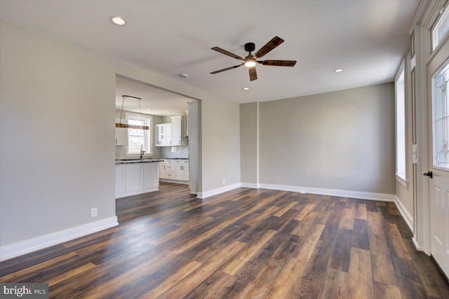 unfurnished living room with recessed lighting, baseboards, dark wood-type flooring, and a ceiling fan