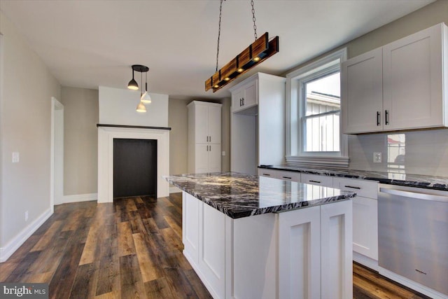 kitchen with dark wood finished floors, dark stone countertops, dishwasher, and white cabinetry