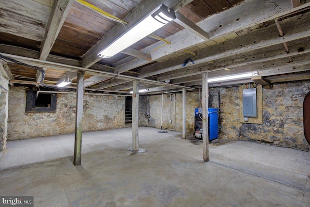 unfinished basement with electric panel and a heating unit