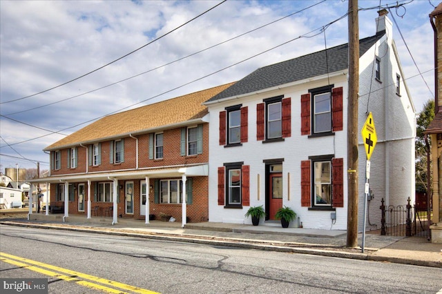 townhome / multi-family property with brick siding and a chimney