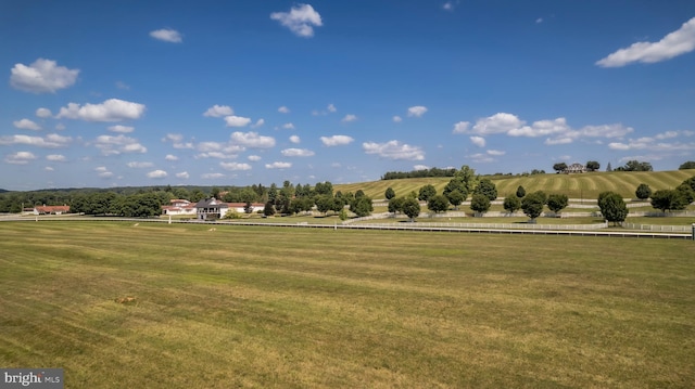 view of property's community with a rural view and a lawn